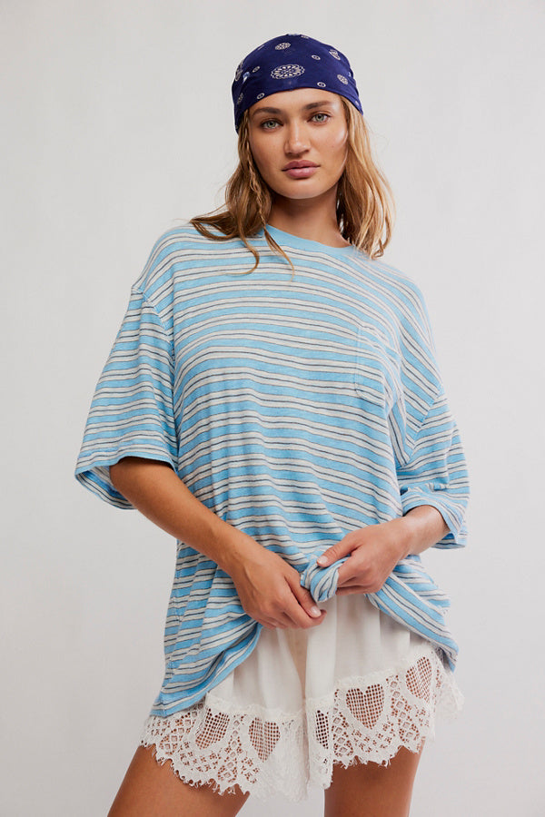 Woman wearing a blue and white striped shirt with a bandana and white lace shorts on a plain background