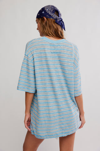 Woman wearing a blue and white striped dress with a bandana on a plain background