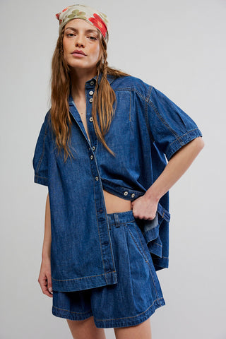 Person wearing a blue denim outfit with a plain background