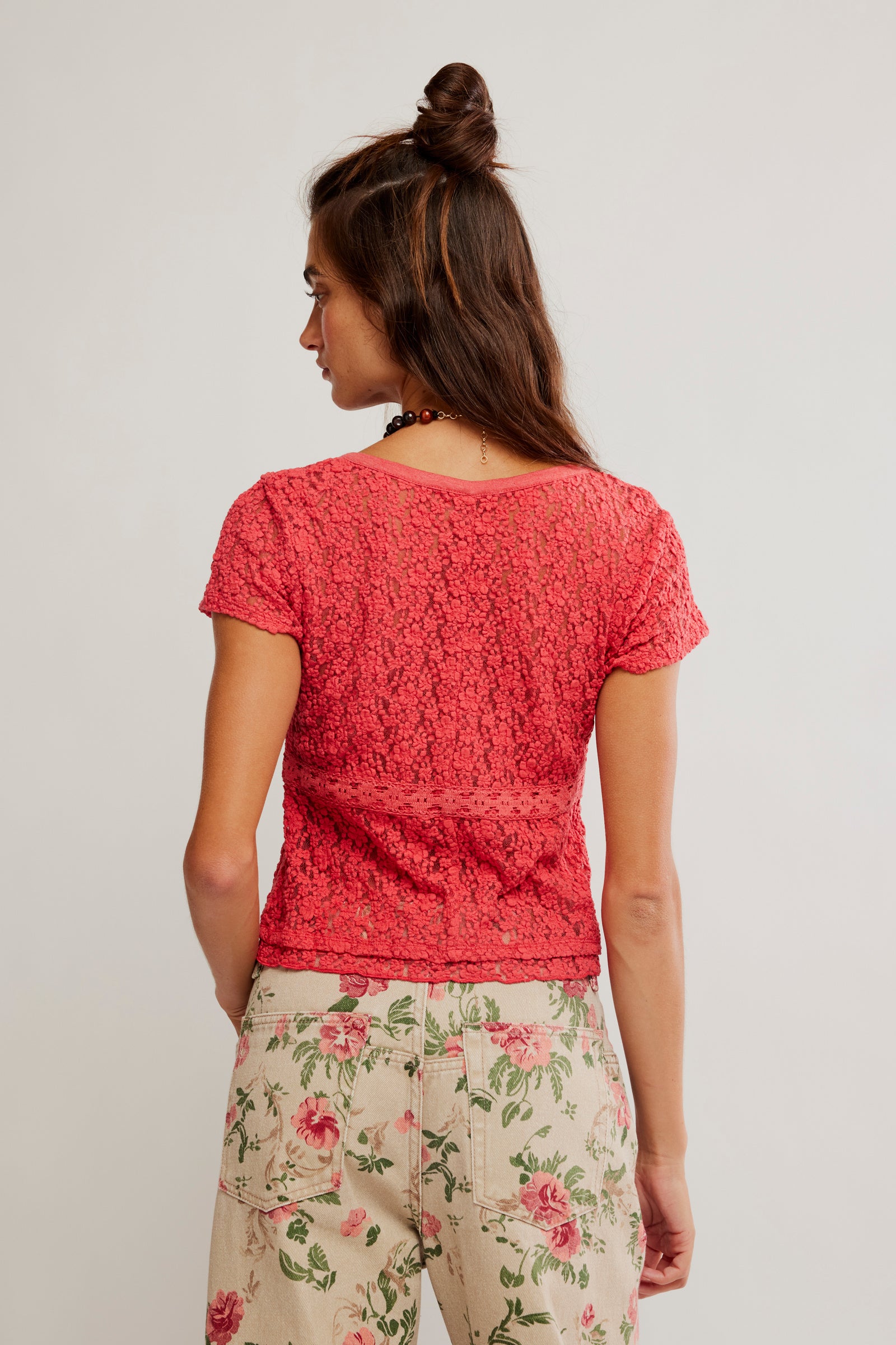 women wearing a red lace top with floral jeans