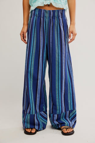 Blue and green striped pants worn by a person on a plain background