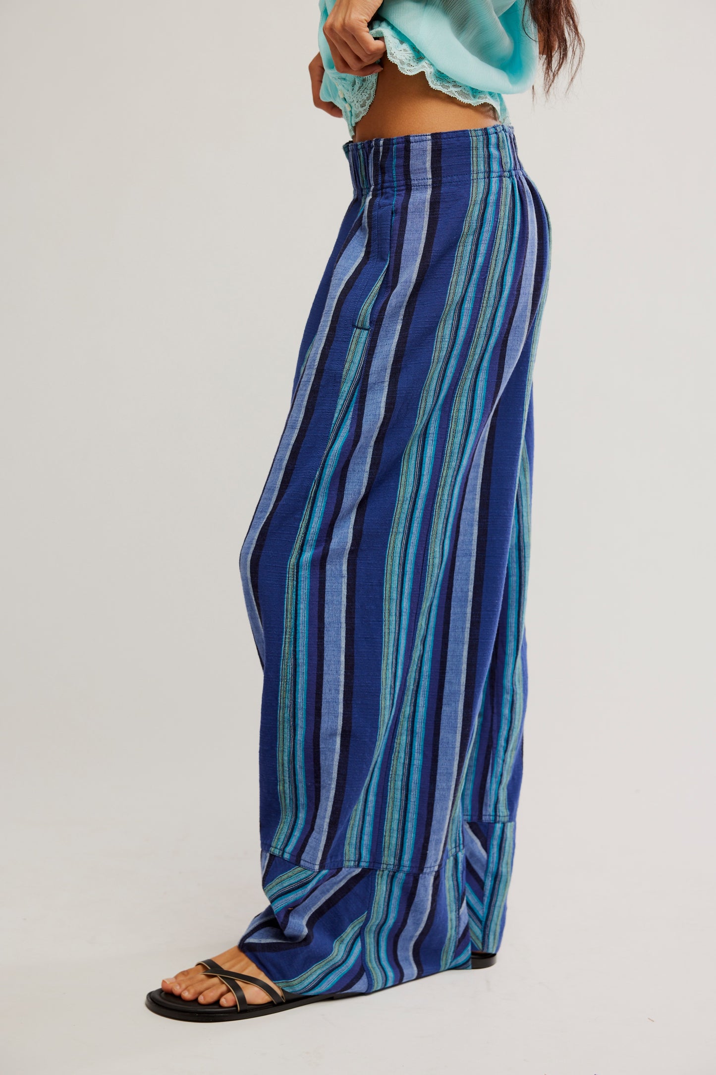 Blue striped pants worn by a person on a white background