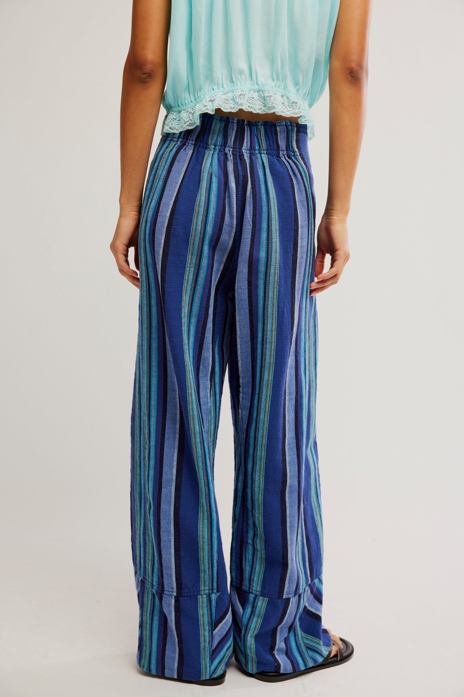 Person wearing blue striped pants on a plain background