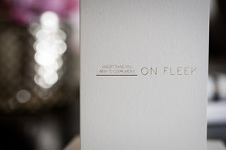 Product packaging with 'On Fleek' branding and text on a blurred background