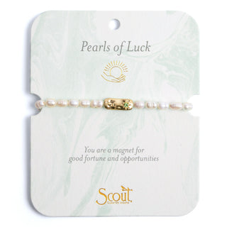 a pearl beaded bracelet with a gold pendant