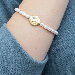 person wearing a beaded pearl bracelet