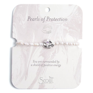 a pearl beaded bracelet with a silver accent on a branded card