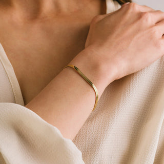 Women wearing a gold bracelet.