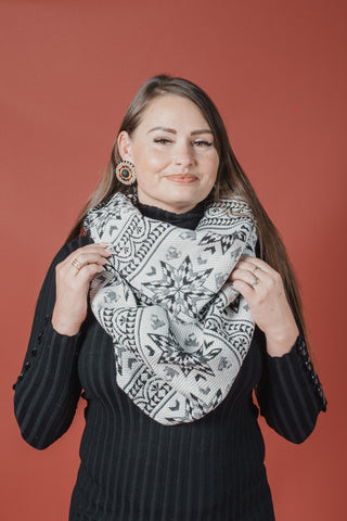 Woman wearing a black and white patterned scarf against a red background