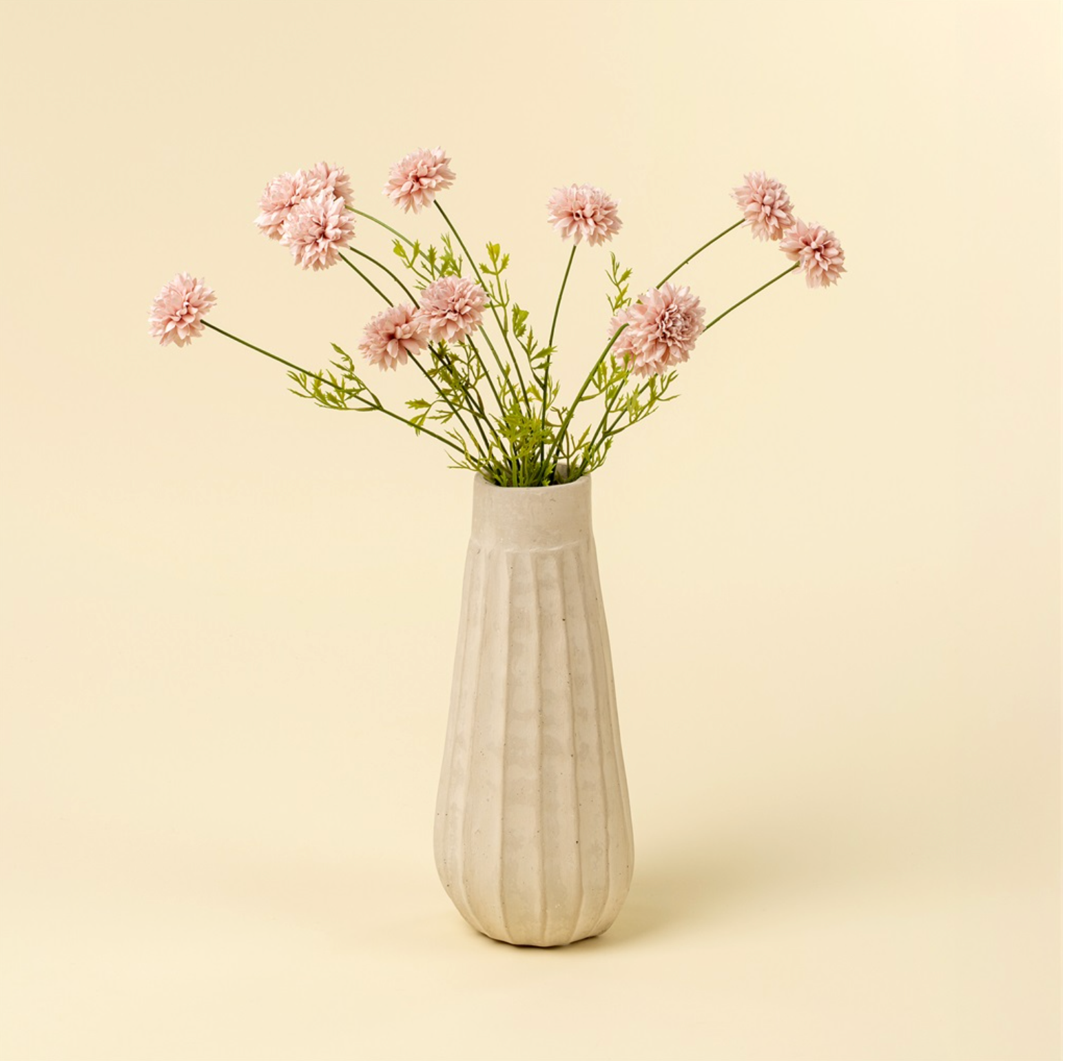 White vase with pink flowers on a beige background