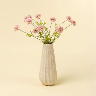 White vase with pink flowers on a beige background
