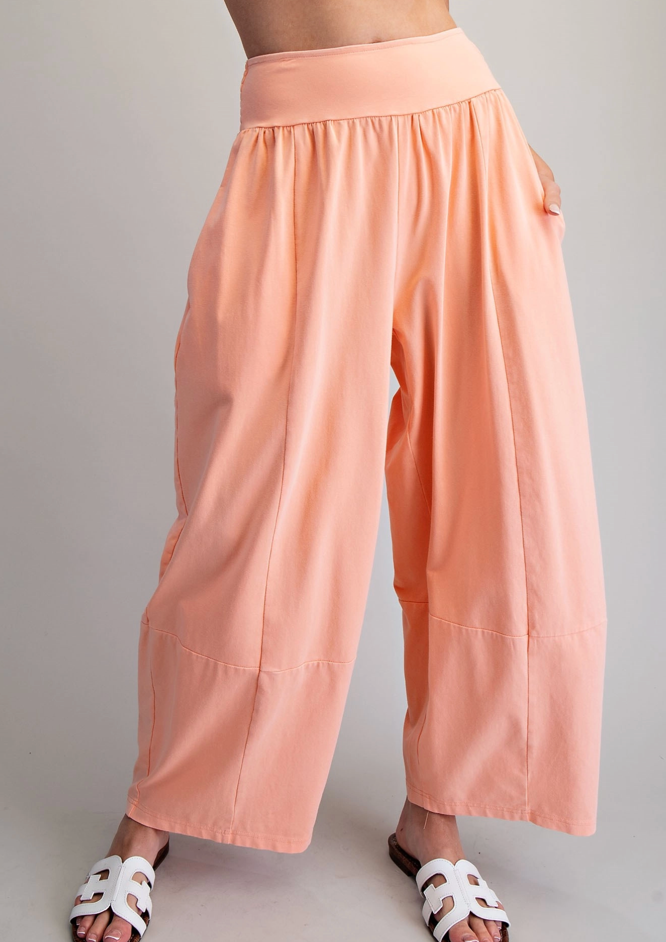 Peach-colored wide-leg pants worn by a person on a plain background