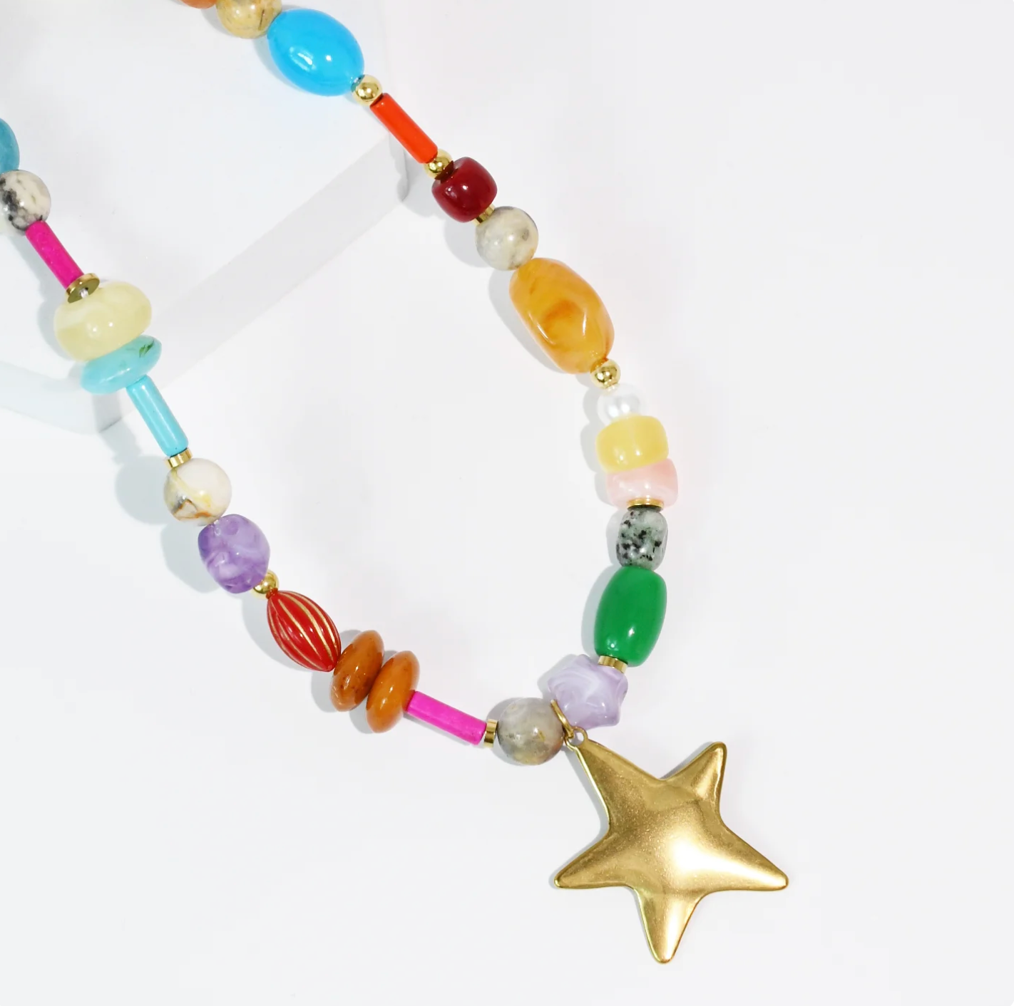 A bright and colourful beaded necklace with a star pendant on it. 