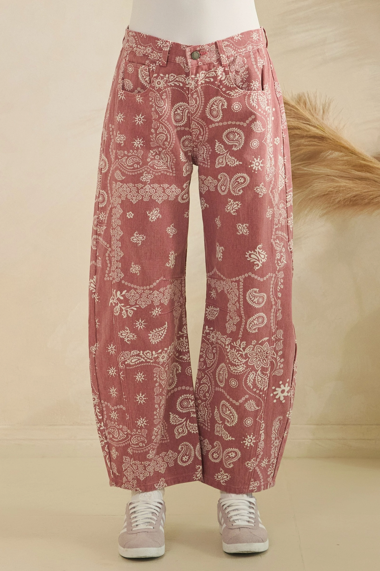 pink patterned pants worn by a person on a beige background