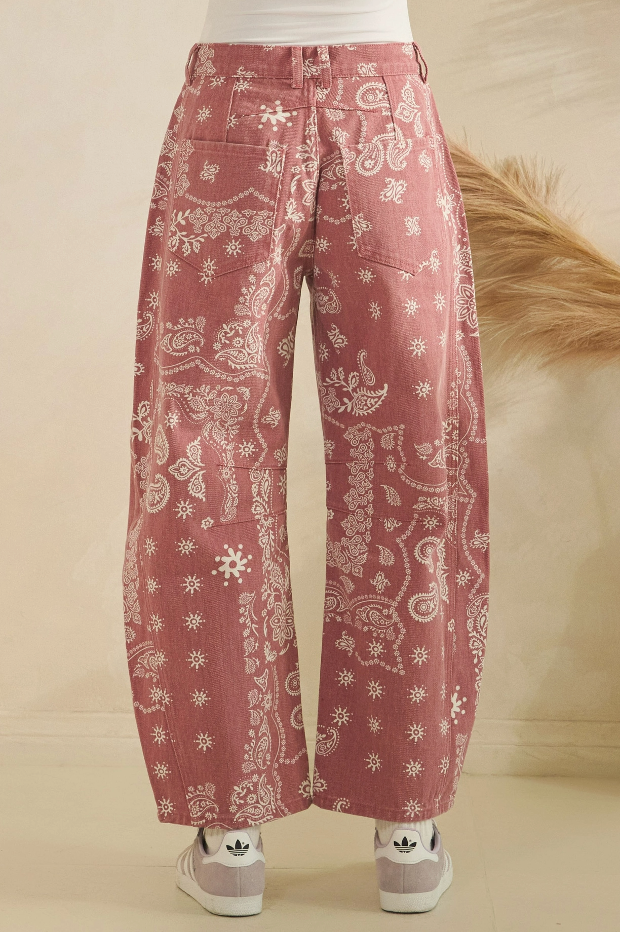 Pink patterned pants worn by a person on a beige background