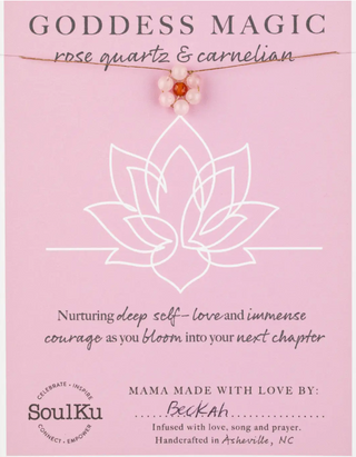 Goddess Magic necklace packaging with rose quartz and carnelian stones on a pink background.