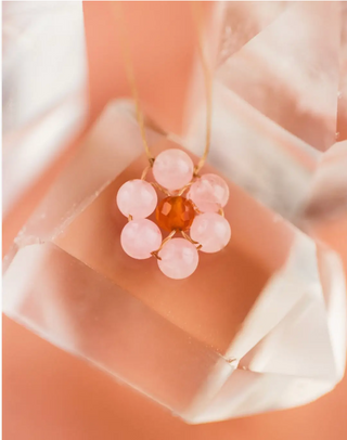 Necklace with pink beads on a soft fabric background