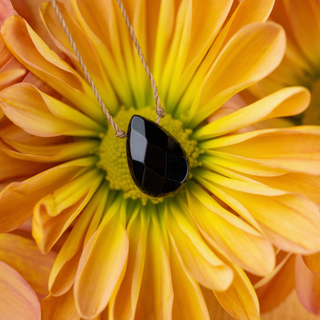 Necklace with a black pendant on a yellow flower