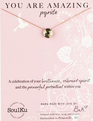 Necklace with a gemstone on a pink card with text and branding