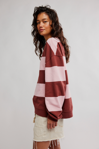 Woman wearing a red and pink striped sweater with a white background