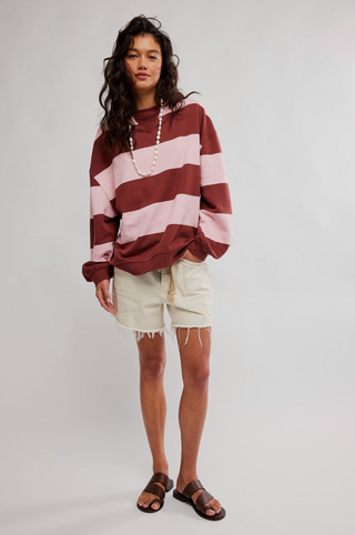 Woman wearing a striped sweater and shorts on a plain background