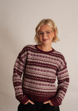 Women wearing a fair isle printed sweater against a neutral photo back drop.
