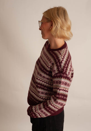 Women wearing a fair isle printed sweater against a neutral photo back drop.