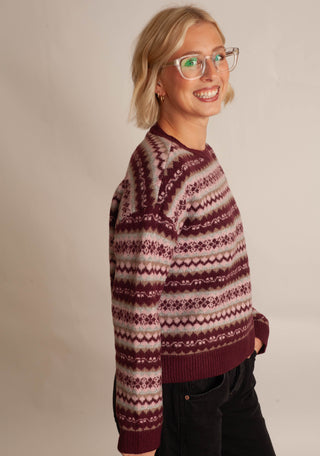 Women wearing a fair isle printed sweater against a neutral photo back drop.