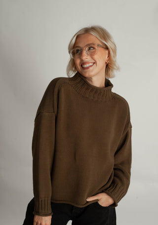Women modelling a funnel neck sweater against a neutral photo back drop.