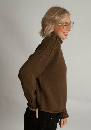 Women modelling a funnel neck sweater against a neutral photo back drop.