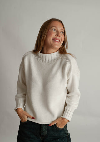 Women modelling a funnel neck sweater against a neutral photo back drop.