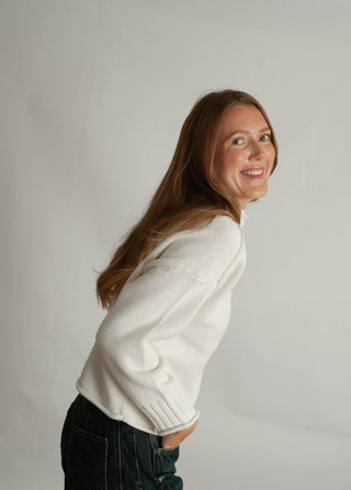Women modelling a funnel neck sweater against a neutral photo back drop.