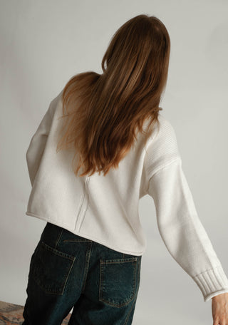Women modelling a funnel neck sweater against a neutral photo back drop.