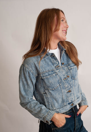 Women modelling a denim jacket against a neutral photo background. 