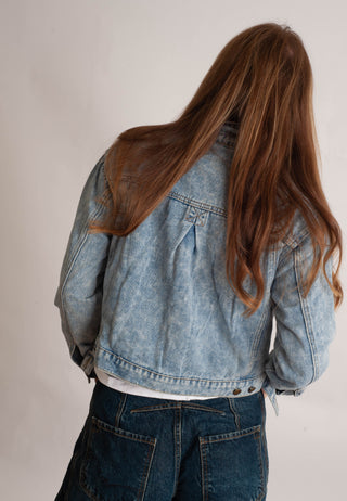 Women modelling a denim jacket against a neutral photo background. 