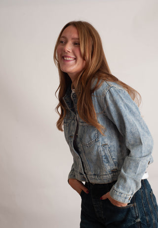 Women modelling a denim jacket against a neutral photo background. 