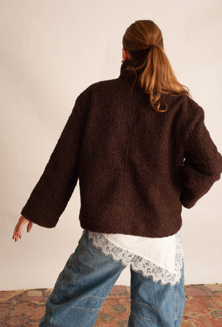 Women modelling a brown sherpa teddy coat against a neutral photo backdrop. 