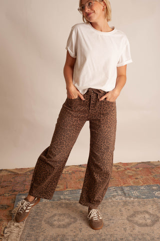 Women modelling a white t-shirt and leopard barrel pants against a neutral photo backdrop.