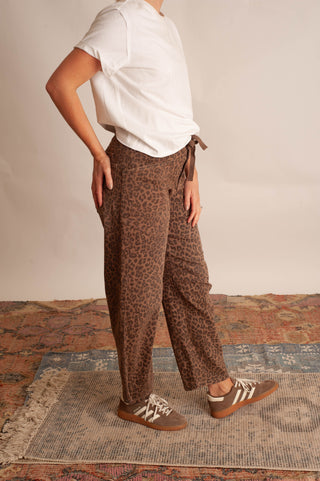 Women modelling a white t-shirt and leopard barrel pants against a neutral photo backdrop.