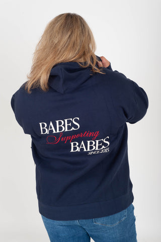 women wearing a navy hoodie with "Babes Supporting Babes" on the back