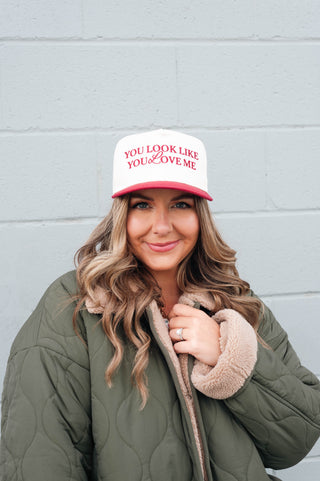Woman wearing a cap with text against a gray wall