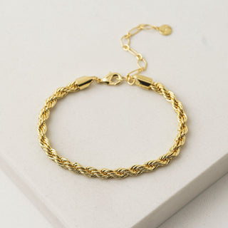a gold twist bracelet on a table