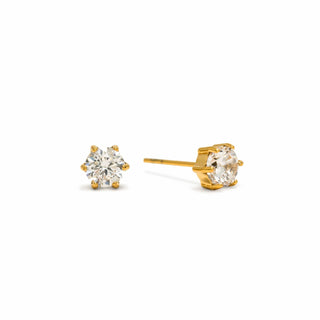 Gold stud earrings with clear gemstones on a white background