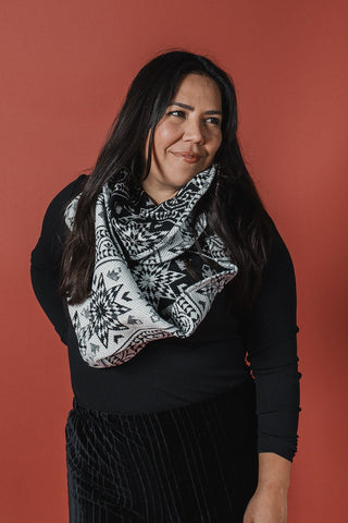 Woman wearing a black patterned scarf against a red background