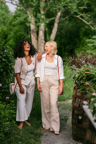 two women in a flower cardigan wearing opposite linen sets.