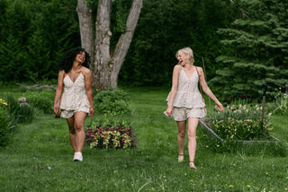 Two women wearing matching outfits walking in a garden.