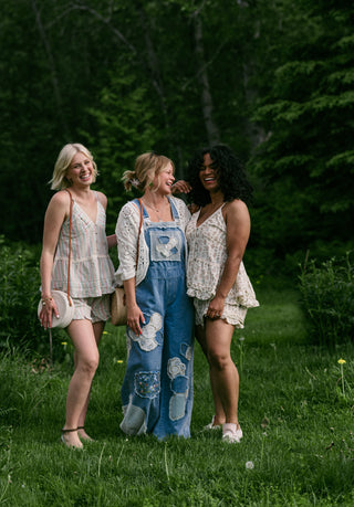 Three women wearing boho inspired outfits in the grass.