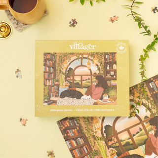 A 1000-piece jigsaw puzzle box by villager, featuring an illustration of a cozy library scene with a person reading and a black cat, styled on a light yellow background with scattered puzzle pieces, a coffee cup, and green leaves.