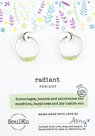 Radiant peridot earrings on a decorative card with floral elements and text.