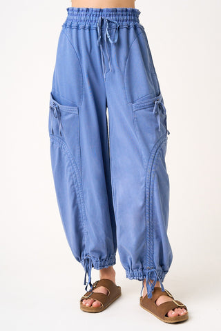 Blue baggy pants worn by a person on a white background